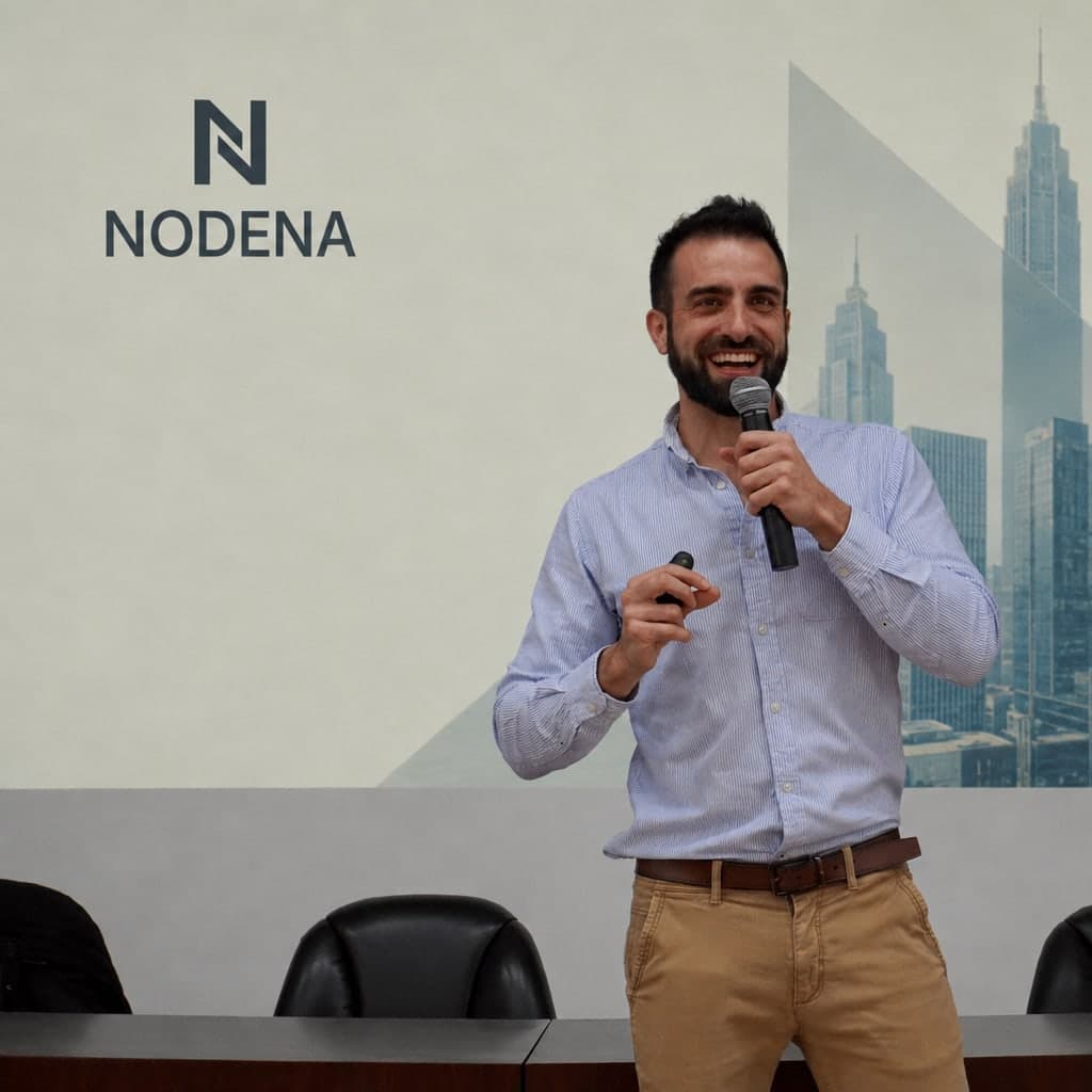 Sergio Carneros presentando ante una pantalla con la marca NODENA.